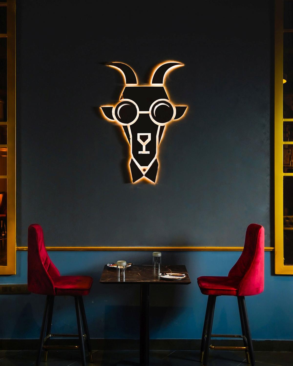 Jamming Goat 3.0 — the signature bespectacled goat in neon above velvet chairs